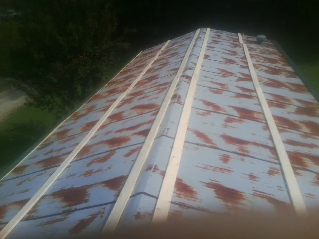 Rusted metal roof panels with new wood purlins before replacement — Storm Damage Roof Repair in Medina by Roofing Brothers