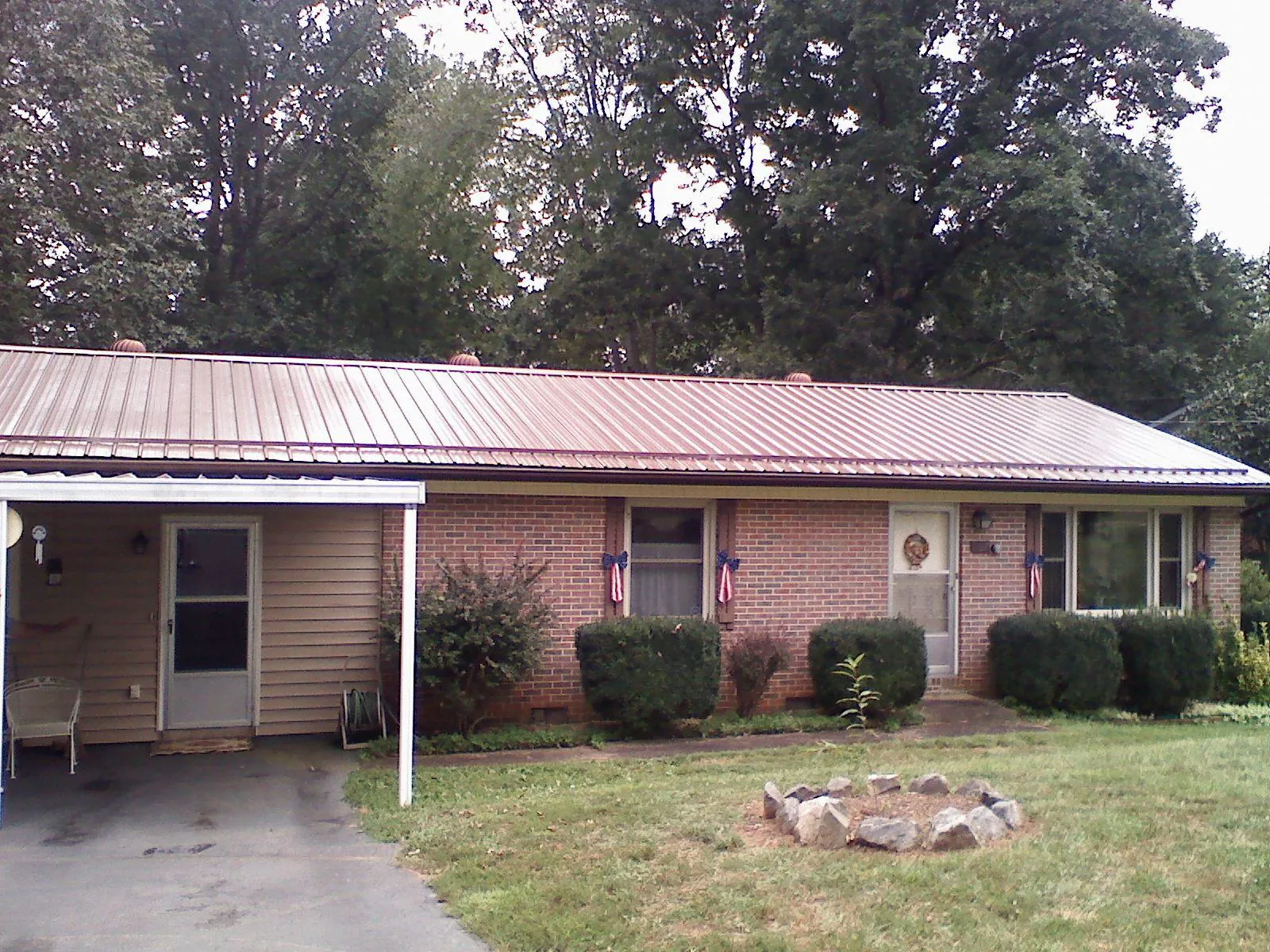 Bronze metal roof and carport on a brick ranch home — Roof Repair work by our crew in Medina